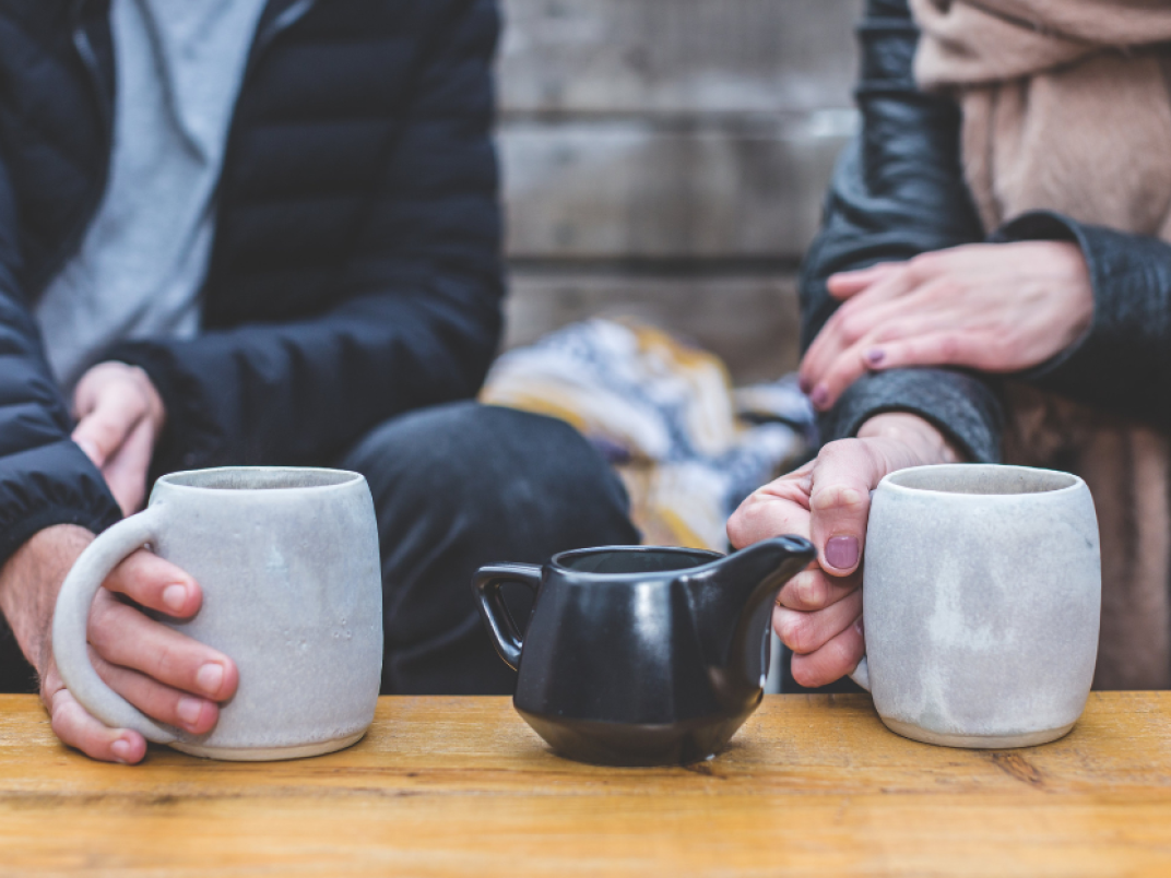 twee mensen drinken koffie en praten